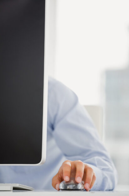 Mid-section of mans hand working on computer in office